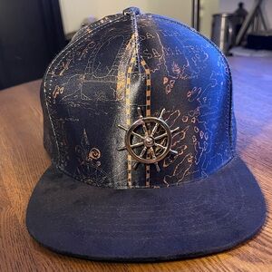Legendary MFGCO Hat in Black and Gold with Boat Wheel and Map Design